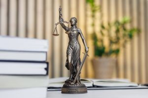 statue of lady justice sitting atop desk next to books