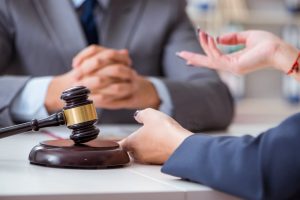 A legal discussion with a gavel on the table between two professionals.
